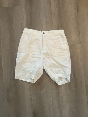 Vita linne-shorts från Zara - Snygga vita shorts i linne med klassisk passform och fickor både fram och bak. Perfekta för varma dagar och har en stilren look med knapp och dragkedja framtill. Passar dig som gillar en fräsch och enkel stil.