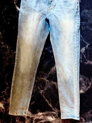 Ljusblå skinny jeans Studio Total - Snygga ljusblå skinny jeans från Studio Total med klassisk femficksdesign och dragkedjegylf. Jeansen har en smal passform och är tillverkade i mjukt denimtyg som ger en bekväm känsla. Perfekta för en avslappnad och trendig look. Blixten strulade den kvällen men det är första bilden som färgen på jeansen. Tror de är 32 or i längd. Normalt brukslitage men inte några hål andra skavanker vad jag kan se.