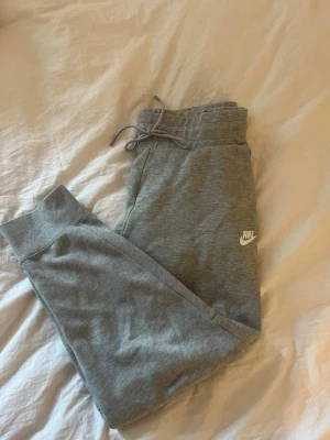 Nike mjukis Byxa  - Säljer ett par grå Nike mjukisbyxor i mycket gott skick, använda fåtal gånger, storlek M. Passar även en S.