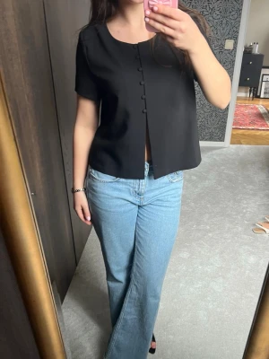 Gina topp med knappar  - Snygg topp med korta ärmar och knappar framtill. Endast använd ett fåtal gånger
