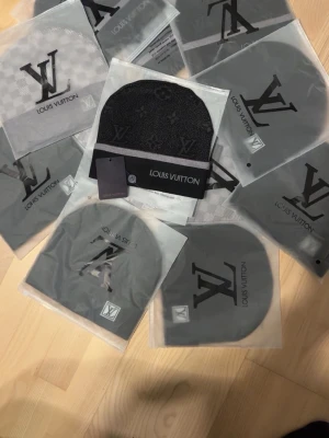 Svart mössa  - Säljer en svart mössa och diskret mönster. Mössan har en grå rand längst ner och är tillverkad i mjukt, stickat material. Perfekt accessoar för dig som vill ha en exklusiv och stilren look.