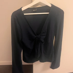 Tröja med knytdetalj från Gina Tricot - Mörkblå tunn tröja med knytdetalj från Gina Tricot. Storlek L. Använd fåtal gånger! 