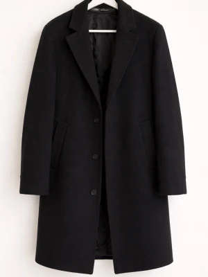 Navy blue klassisk kappa från Zara - Stilren Navy blue kappa från Zara med rak passform och tre knappar framtill. Kappan har klassisk krage, två snedställda fickor och är helfodrad. Perfekt för dig som gillar en tidlös look och vill hålla dig varm under kyliga dagar.