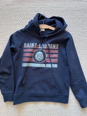 Saint Laurent hoodie - Hej och välkommen till liljestrands nu säljer vi en saint Laurent hoodie i bra skick utan större defekter sitter mer som xs skulle jag säga osäker på äktehet därav priset kom med frågor osv mvh liljestrands