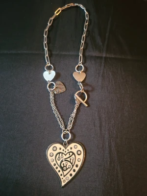 Z&R halsband med hjärthängen - Unikt halsband från Z&R i silverfärgad metall med flera hjärtformade hängen och en stor hjärtberlock med dekorativa detaljer och stenar. Kedjan har både grova och tunnare länkar samt en snygg toggle-låsning. Perfekt för dig som gillar statement-smycken och cool design.