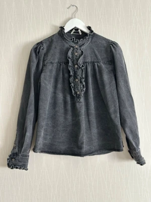 Grå volangblus från Neo Noir - Neo noir ruffle denim blouse Heavy denim fabric, like jacket material. Or.pris 799