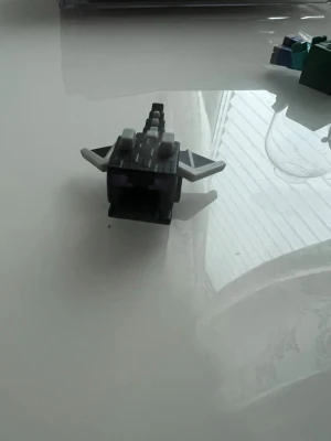 Kinder joy - Minecraft Enderdrake i LEGO-stil - Säljer en liten byggfigur av Enderdraken från Minecraft, gjord av svarta, gråa och vita LEGO-liknande bitar. Figuren har vingar och svans, perfekt för dig som gillar gaming och samlarprylar.