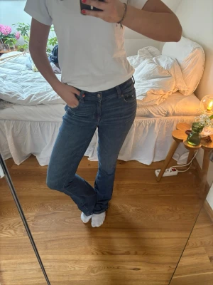 Blå bootcut jeans - Säljer ett par klassiska blå bootcut med fem fickor. Jeansen har en snygg tvätt och sitter tajt över låren för att sedan bli vidare nedtill. Perfekta till en enkel t-shirt eller hoodie. Mycket stretchiga 