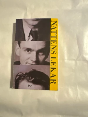 Nattens lekar av Stig Dagerman - Nattens lekar av Stig Dagerman är en skönlitterär bok med ett omslag i svartvitt och gult. Boken har porträttbilder på framsidan och tydlig gul rygg med svart text. Perfekt för dig som gillar svensk litteratur och klassiska romaner.