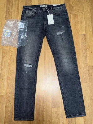 Säljer ett par Lindbergh jeans Grey – Size W31 L32 - Jeansen är endast testade. I mycket bra skick utan synligt slitage.  Stilrena jeans i modern passform med stretch för extra komfort, passar perfekt till både vardag och mer uppklädda tillfällen. Original tags medföljer.  Size: W31 L32 🏷️ Rabatt vid köp av flera plagg!