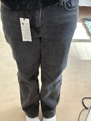 Grå raka jeans - Säljer ett par gråa jeans från Monki med rak passform och klassisk femficksdesign. Jeansen har hög midja och är tillverkade i ett mjukt denimtyg. Perfekta för en avslappnad och trendig look. Prislapp kvar!