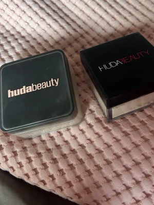Huda Beauty löspuder transparent - Löspuder från Huda Beauty i transparent färg. Har fått både i present och anväder ej dom. Dem är 90% fulla. Nyansen är Pound Cake. Perfekt för mellanbrun/vetefärgad hud. (Säljer både för 500krk). Ordpris 500/st