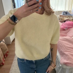 Ljusgul stickad tröja med kort ärm - Säljer en söt ljusgul stickad tröja med korta ärmar. Den har använts några gånger men har inget som helst tecken på slitage💛