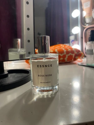 ESSNCE Rose Rose Eau de Parfum - Fräsch parfym från ESSNCE med doft av rosor. Flaskan är cylindrisk i genomskinligt glas med en stilren silverfärgad kork. Minimalistisk etikett med svart text. Perfekt för dig som gillar blommiga och eleganta dofter.