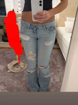 Ljusblå slitna bootcut jeans - Säljer ett par ljusblå,lowaist,bootcut jeans i str 26:32🥰Köpt för 1600, men säljer för 1500 endast!