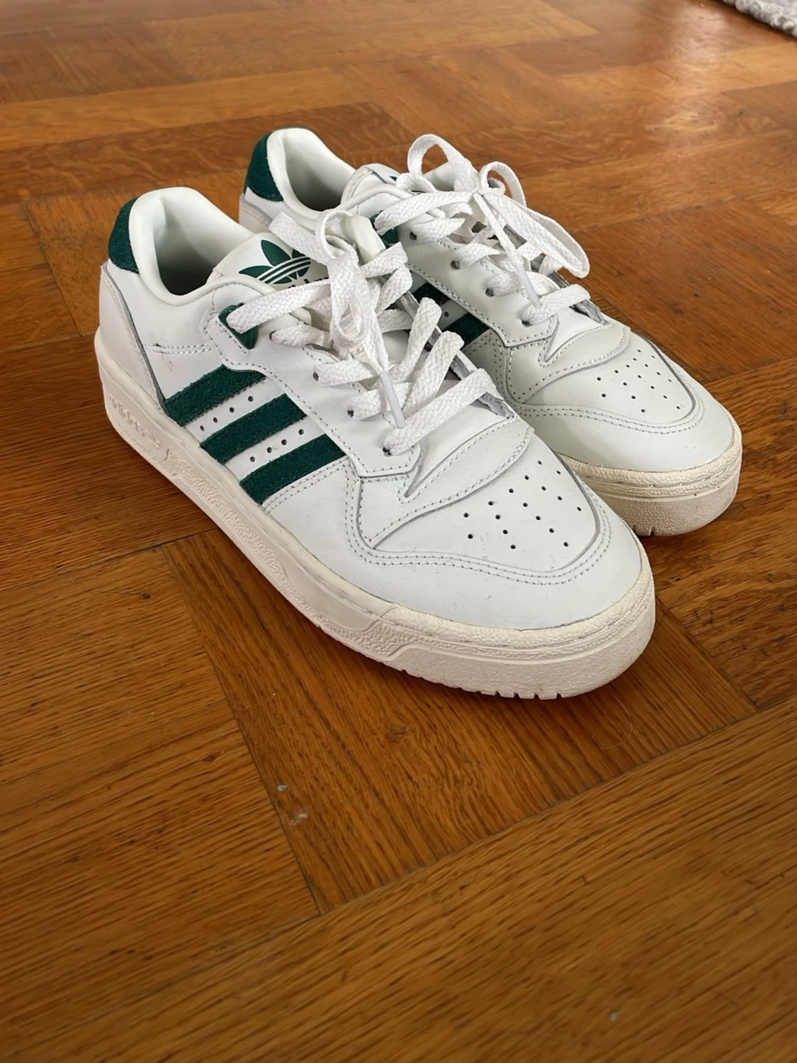 Vita Adidas sneakers med gröna ränder