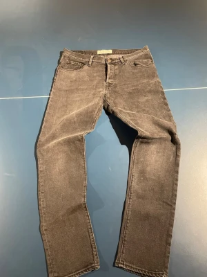 Jeanerica  - Snygga grå jeans i klassisk rak modell med fem fickor och normal midja. Jeansen är tillverkade i denim och har en lätt tvättad look som ger en cool vintagekänsla. Passar perfekt till en avslappnad streetstyle.