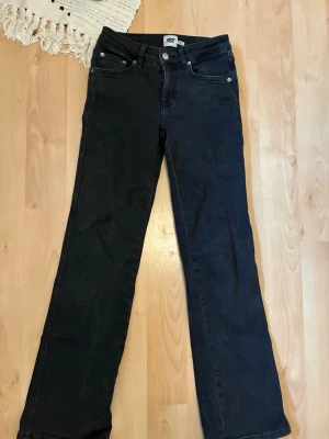 Svarta raka jeans från 157 - Säljer ett par svarta jeans från 157 med rak passform. Jeansen har silverfärgade knappar och nitar samt detaljerade bakfickor med lock och knapp. De är i super bra skick och storlek 164.