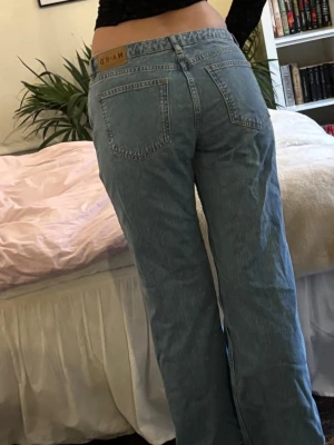 Blå raka low waist jeans från NA-KD - Säljer ett par klassiska lågmidjade blå jeans från NA-KD med rak passform. Jeansen har två bakfickor och är tillverkade i denim. Perfekta för en avslappnad och trendig look.