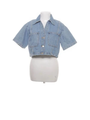 Kort jeansjacka med vida ärmar - Ljusblå croppad jeansjacka med korta, vida ärmar och två stora bröstfickor. Klassisk krage och knappstängning framtill. Perfekt för en avslappnad och trendig look. Köpt på Sellpy därav bilderna🌸