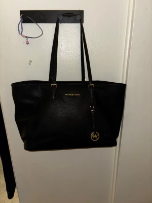 Mk väska  - Jag säljer en mk väska i bra skick det ända som är lite lite skavt är axelbanden men de går att byta men det är inget man tänker på.jag vill helst att man hämtar annars postar jag spårbart med PostNord 