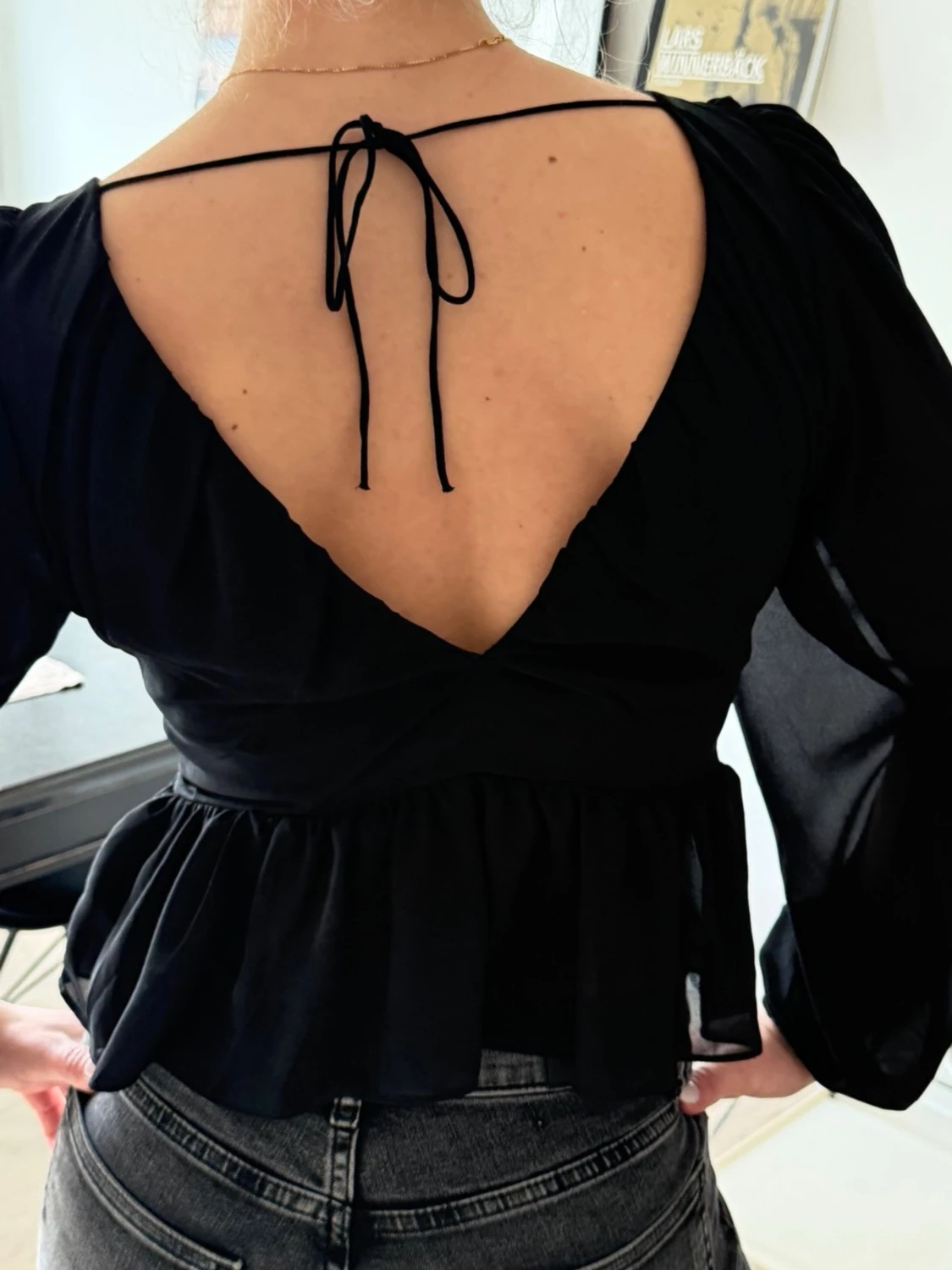 Svart v-ringad blus med volang - 1