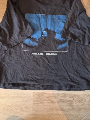 Billie eilish t-shirt - En cool baggy t-shirt från Billie eilish. Denna tröjan kommer från hennes senaste album!