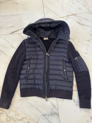 Moncler Cardigan Mörkblå - Mörkblå moncler cardigan, nfc funkar. Väldigt bra kvalite. Storlek S, längd: ca 60 cm. Armhåla till armhåla: ca 53 cm.