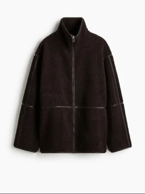 Svart teddyjacka med dragkedja - Mysig svart teddyjacka med hög krage och hel dragkedja framtill. Jackan har en oversized passform och markerade sömmar som ger en cool look. Perfekt för att hålla värmen under kyliga dagar. Använd vid endast några tillfällen och på ett sparsamt sätt. Storlek L. Kan även byta mot M ifall möjligt 