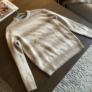 Beige Stickad Tröja  - Beige stickad tröja från Lager 157 med diskreta breda ränder i olika nyanser. Tröjan har rund hals, ribbade muddar vid ärmslut och nederkant samt långärmad passform. Perfekt för dig som gillar en chill och stilren look.                  Endast använd EN gång - S men passar M