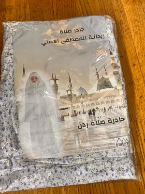 Blommig bönesjal från SARAD - Säljer en traditionell bönesjal (jader salah) från SARAD i vitt tyg med blått och grått blommönster. Perfekt för dig som vill ha något bekvämt och täckande vid bönestunder. Lätt material och enkel att ta på.