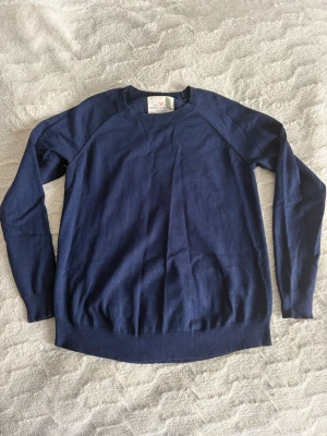 Mörkblå stickad tröja - En jättefin mörkblå stickad tröja från Lindex i strl XS. supermysig och enkel att matcha till typ allt. Använd få gånger så i bra skick, men säljer eftersom det inte riktigt är min stil längre. Som ni ser på baksidan av tröjan är det som en ”vit rand” vet inte vad det är men bara så ni ser det. 