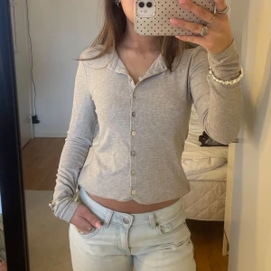 Ljusgrå ribbad kofta från zara - En långärmad grå tröja med knappar från zara. Mjukt och stretchigt material, knappt använd, inga defekter. Går att vika upp som på bilden om man vill få den kortare. Passar både xs och s😊