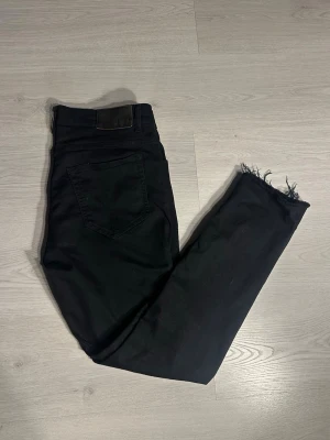 T/J 33/34 - Ett par riktigt snygga tiger of sweden jeans med slitningar vid bensluten. Säljer för de inte riktigt min stil men de går nog såklart att klippa bort bara om man inte skulle gilla det. Jeansen är i mycket bra skick och utan stora defekter. Skriv vid frågor och kolla gärna in min profil för fler jeans, bälten och tröjor. Vid köp av fler plagg kan man få ett schysst paketpris:)