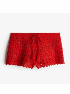 Virkade shorts - Snygga röda strandshorts i virkad design med dekorativt knytband och tofsar framtill. Shortsen har ett genombrutet mönster och vågig kant nedtill, perfekta att dra över bikinin på stranden. ❣️