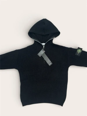 Stone Island Quarter-Zip Knit Hoodie – Storlek M (Helt ny!) - Säljer nu denna sjukt snygga Stone Island-tröja i svart stickat material. Det är en kombination av en klassisk quarter-zip och hoodie, vilket ger en riktigt lyxig men avslappnad look.  Tröjan är helt ny med alla tags kvar och har självklart den ikoniska Stone Island-patchen på vänster ärm. Perfekt för både vår och höst då stickningen är rejäl och håller hög kvalitet.  Skick: 5/5 (Helt ny/oanvänd med tags)  Storlek: Medium (M)  Färg: Svart  Detaljer: Dragkedja vid kragen, luva och avtagbar patch.
