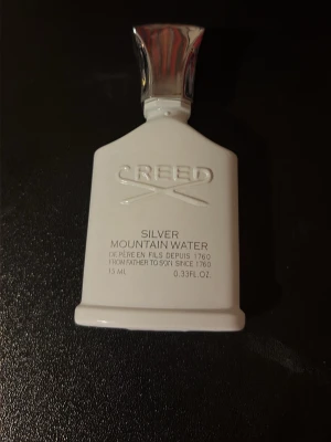 Creed Silver Mountain Water 15 ml - Creed Silver Mountain Water är en exklusiv parfym i en stilren vit flaska med silverfärgad kork. Flaskan rymmer 15 ml och kommer i en elegant vit kartong med guld- och silverdetaljer. En lyxig doft som sticker ut med sin fräscha och unika karaktär.