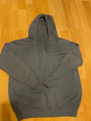 ljusblå kashmir hoodie - En enkel och stilren ljusblå kashmir hoodie med huva och dragsnören. Hoodien har ribbade muddar vid ärmslut och nederkant samt raglanärmar för en avslappnad look. Ser grå ut pga ljuset men är väldigt ljusblå. Nypris 1200. Pris kan diskuteras vid snabb affär.
