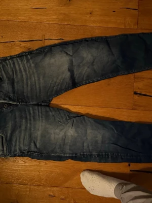 Blå jeans  - 32/32Säljer ett par blå jeans med snygg tvättad effekt och raka ben. Jeansen har klassiska fem fickor och synliga sömmar. Perfekta för en avslappnad och trendig stil. Materialet är denim i bomull.