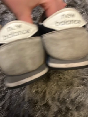 Svarta New Balance sneakers passar 37 38 - Snygga svarta sneakers från New Balance med vita detaljer och klassisk N-logga på sidan. Skorna har lågt skaft och en kombination av mocka och textilmaterial. Perfekta för en avslappnad streetwear-look.