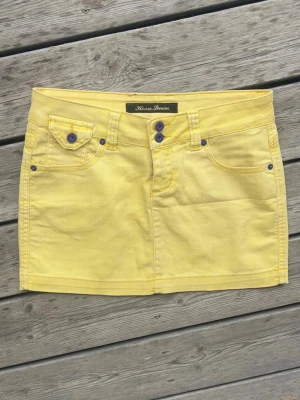 Ljusgul jeanskjol  - Lågmidjad gul jeanskjol med diamanter! Midjemått: 37cm, längd: 29cm.  Kolla in min profil för fler plagg!