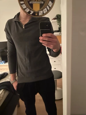 Två halvzip-tröjor i mörka färger - Säljer två stilrena halvzip-tröjor, en i mörkgrått och en i marinblått. Båda har lång ärm, hög krage med dragkedja och smal passform. Perfekta för en clean och enkel look. Materialet känns mjukt och stretchigt, troligen bomull eller bomullsblandning. Knappt andvända, 329 för båda!