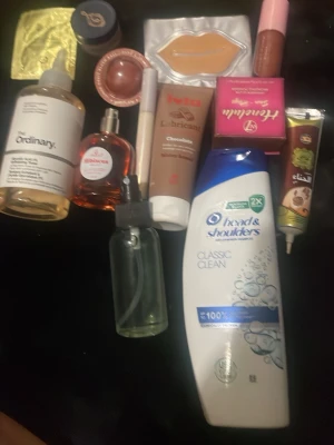 Blandat skönhetspaket med hudvård - Ett mixat paket med skönhetsprodukter som inkluderar ansiktsvatten från The Ordinary, Head & Shoulders schampo, Johnson's olja, läppmask, läppbalsam, ansiktskräm, serumflaska, och olika krämer. Perfekt för dig som vill testa olika märken och produkter inom hud- och hårvård.