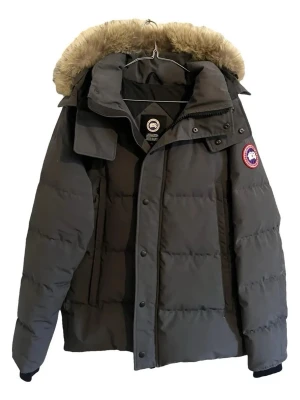 Mörkgrå dunjacka från Canada Goose - Snygg mörkgrå dunjacka från Canada Goose med avtagbar huva och beige päls. Jackan har klassisk patch på ärmen, dragkedja och knappar framtill samt två stora fickor. Perfekt för kalla dagar och riktigt varm tack vare dunfyllningen.
