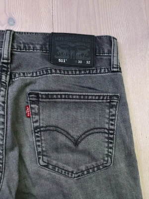 Levi's 511 grå jeans W30 L32 - Säljer ett par grå Levi's 511 jeans med klassisk femficksdesign och raka ben. Jeansen har en snygg tvättad look och är i superfint skick utan minsta defekt: skick 10/10 