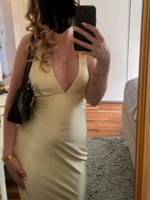 Gul långklänning  - En gul långklänning i satin liknande material. Använd 2 gånger och i gott skick. Perfekt för bal eller andra tillställningar.