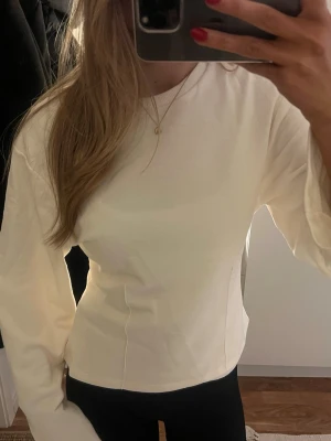 Cremefärgad figursydd topp - En söt cremefärgad figursydd topp med långa armar🩷