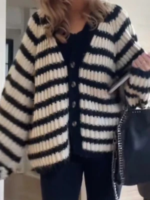 Randig oversized stickad kofta från Gina Tricot - Mysig stickad kofta från Gina Tricot i svart och vit randigt mönster. Finns inte på hemsidan längre! Har en liten defekt vid knappen som inte syns när den används eller påverkar koftan 