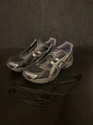 Asics-gel 1130 /Black/ - Köptes för 2 månader sen från zalando.Har inte själva asics skoboxen men skickas med en skobox.Har typ 2-3 trasigmärken i skorn men fungerar bra och är sköna.Skösnören sätts på frivilligt sätt.