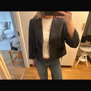 Kort kavaj - Så fin randig kavaj, med rosetter på fickorna! Står storlek XL i men skulle säga att den sitter som en S. Marinblå/grå färg med bruna ränder